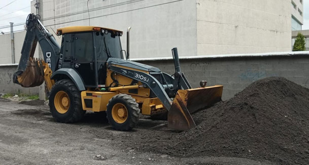 Retroexcavora moviendo material dentro de una terreno para limpieza  